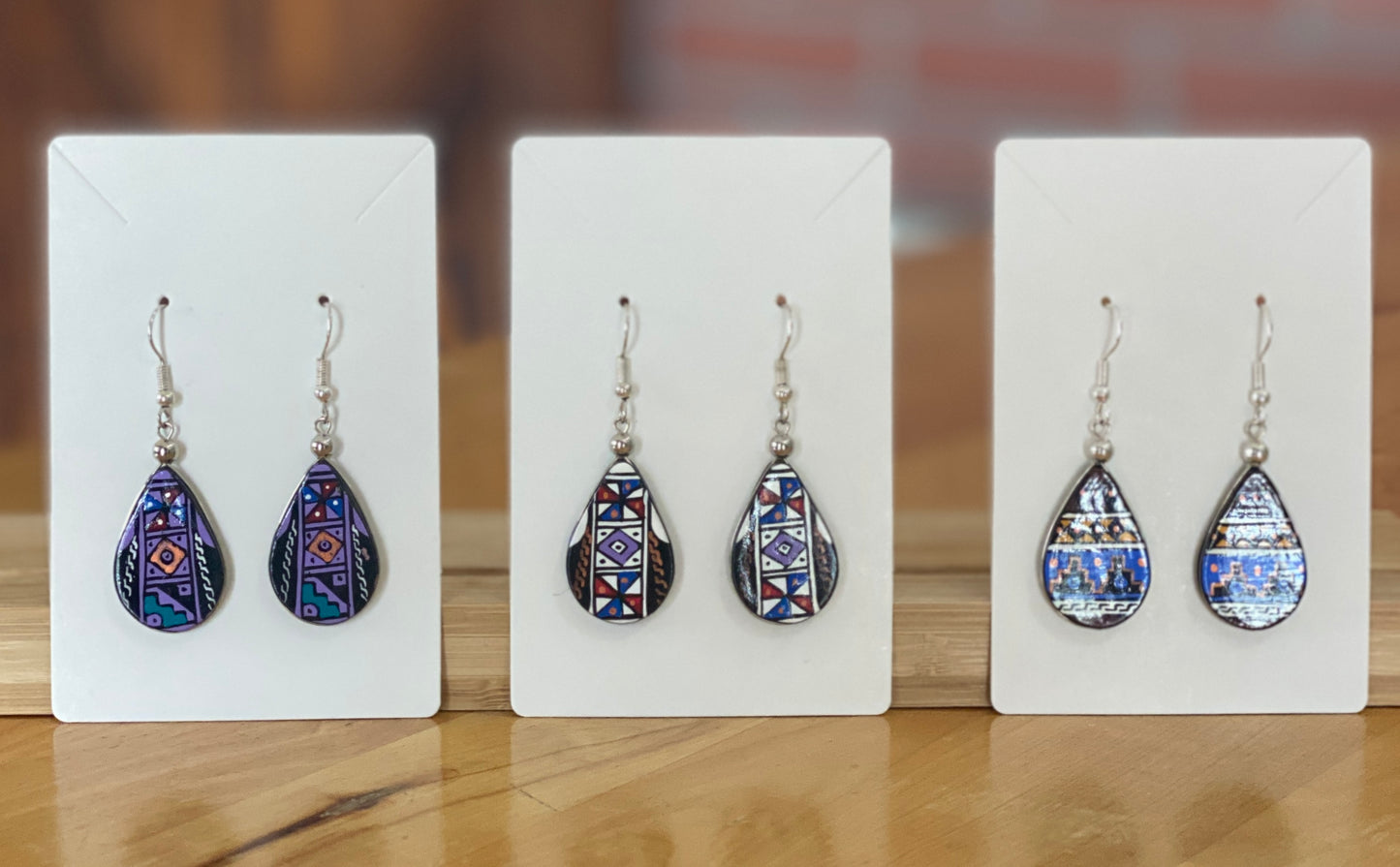 Hand painted wooden tear drop shaped dangle earrings. Authentic hand painted Inka symbols dangle earrings. Sterling Silver Hooks Available.